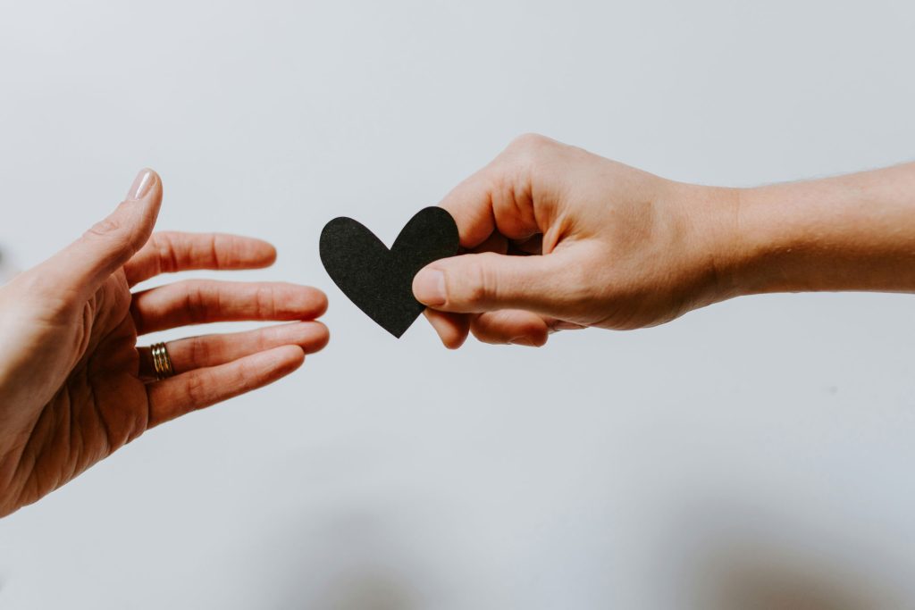 supporting women in scotland a hand passing a paper love heart to another